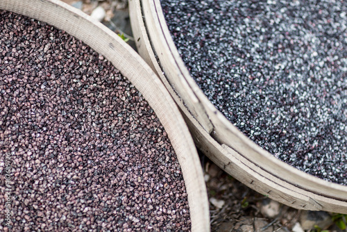 Close-up of raw cochineal in baskets on a grassy background.