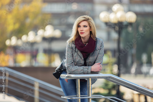 Young fashion blonde woman in checked plaid blazer and snood scarf