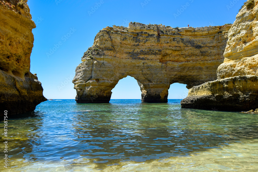 Ocean beach, cliffs and craved arches by ocean and wind forces. Coastal landscape, Atlantic ocean, Algarve south Portugal. 