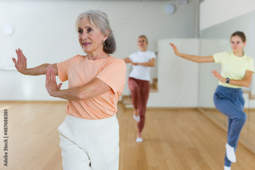 Mature woman with family enjoying active dances in modern dance studio