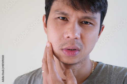 Teetch problem. Asian male with painful cheek swelling or dental abscess. A facial injury, tooth abscess, salivary stones, salivary gland tumor. photo