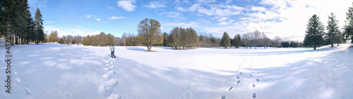 Panoramic photo of the public park on deep snow with footprint for a winter weather concept.