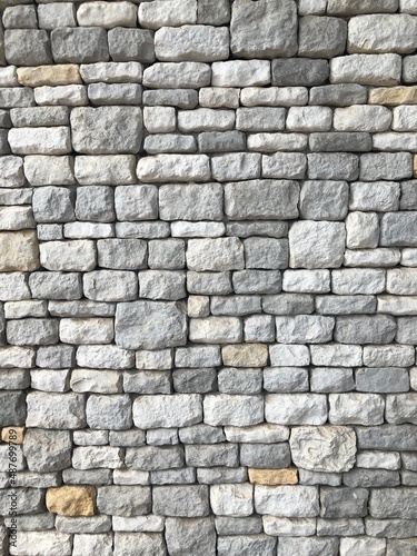 Direct view of decorative natural cobble stone wall with different shades of grey and sizes, shadow gap. Natural texture and form. Exterior wall covering.