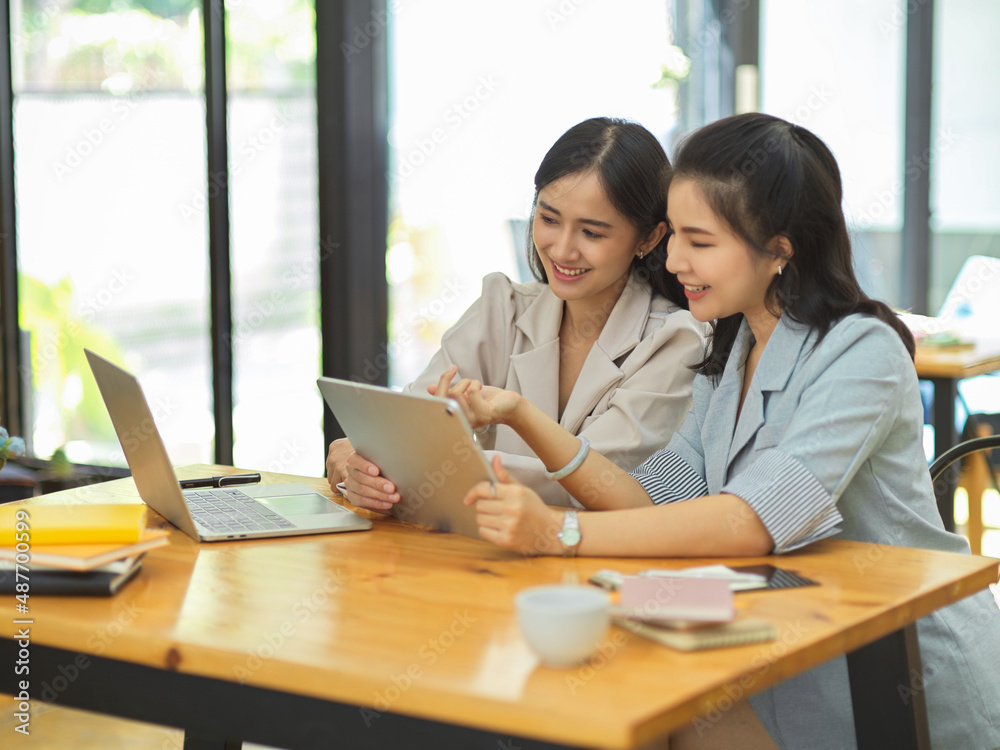 Businesswomen are talking and looking some content on the internet Businesswomen are talking and looking some content on the internet