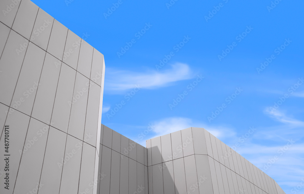 Sunlight on surface of white modern building wall against blue sky in low angle view, architecture background concept