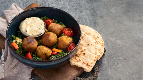 Falafel with hummus on dark background.