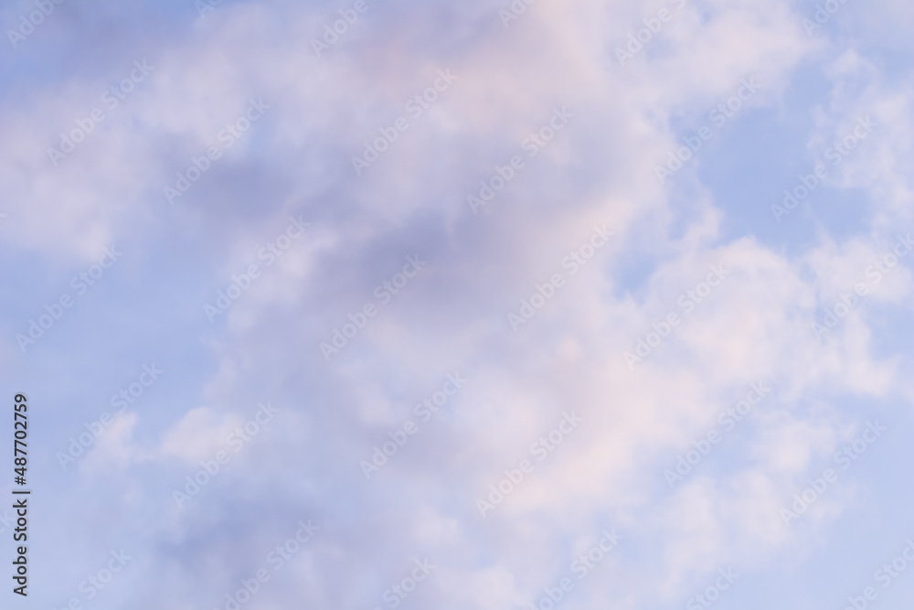 Background of blue sky with white pink clouds at sunset