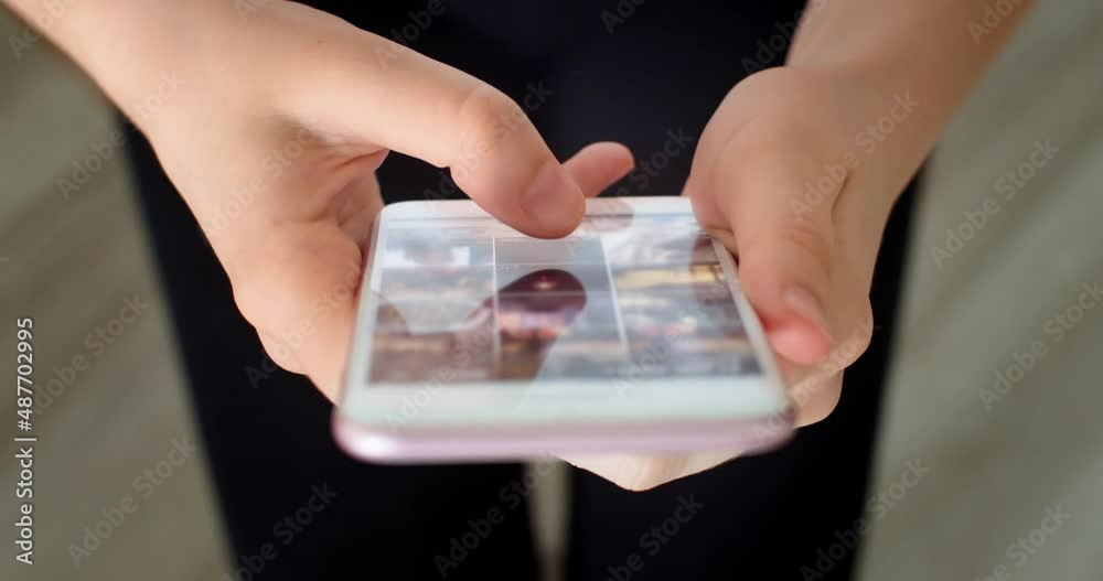 Close-up shot of hands using smartphone surfing in internet. Scrolling news feed with pictures or photo gallery choosing content for social media or instagram. Mobile gadget and technology concept