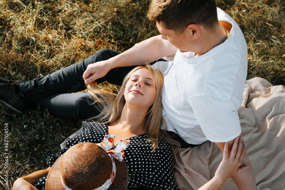 © Sergio - Young loving couple enjoying outdoor recreation together, man caressing woman with closed eyes, flirting during romantic date outdoors. Close-up, top view