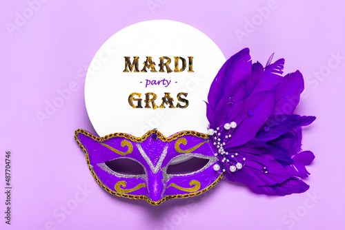 Mardi gras lettering. Congratulation card with mask on white podium on violet background Top view 2022 Mardi Gras Parade Schedule