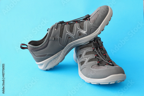 Fashion sneakers with laces stand on blue paper