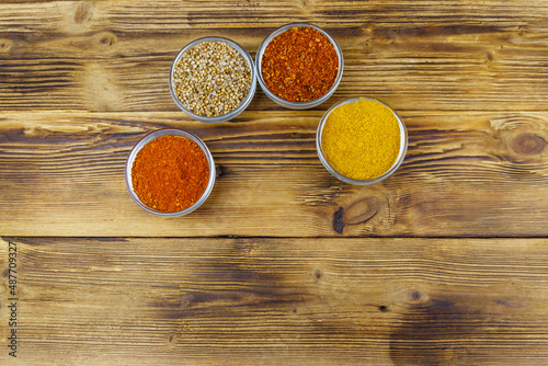 Set of different aromatic spices on wooden table. Top view