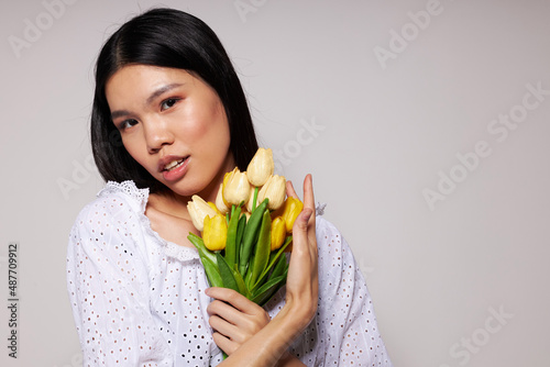 woman romance bouquet of flowers near the face light background unaltered