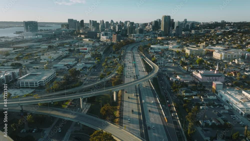 Cinematic aerial downtown San Diego busy highway to modern buildings at sunset