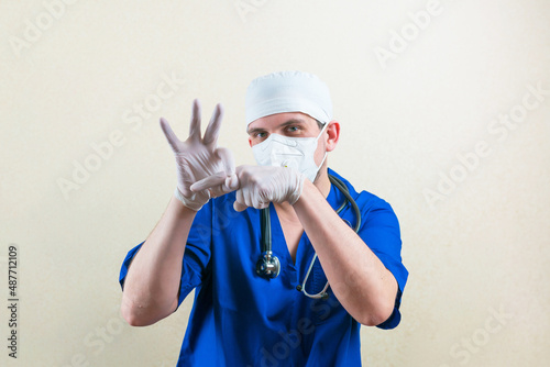 Doctor in a blue uniform shows obscene gesture simulating sex or penetration sign. photo