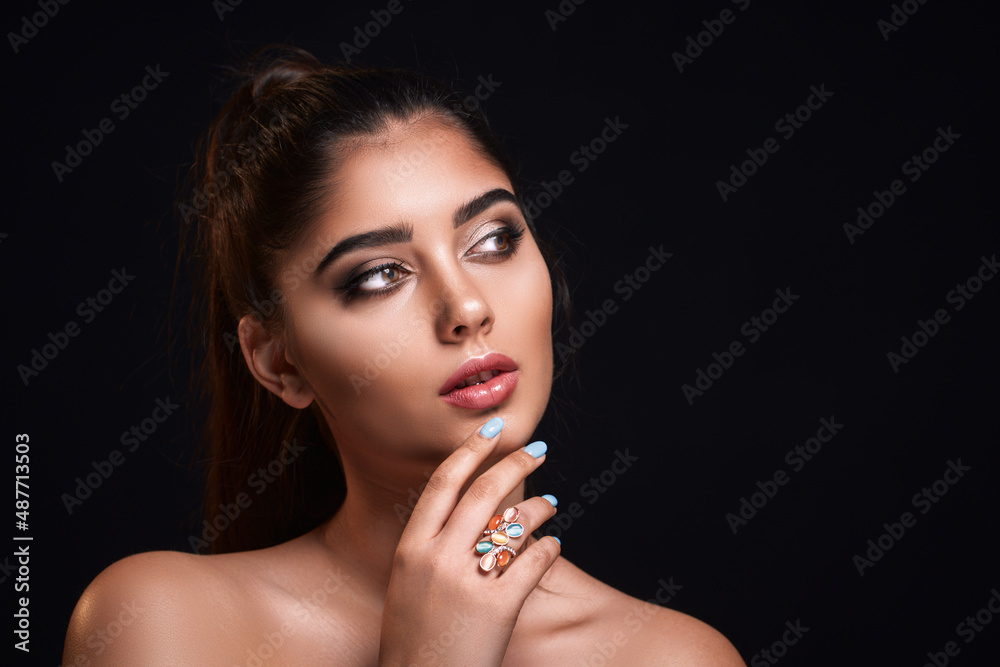 portrait of beautiful Indian woman who advertises ring isolated on dark background. Jewelry concept portrait of beautiful Indian woman who advertises ring isolated on dark background. Jewelry concept