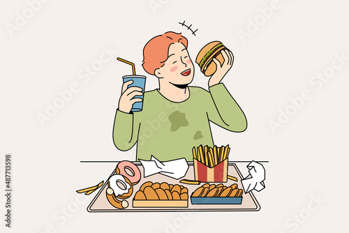 Unhealthy eating in childhood concept. Smiling cheerful fatty boy sitting and eating hamburger donuts french fries drinking lemonade enjoying junk food vector illustration 