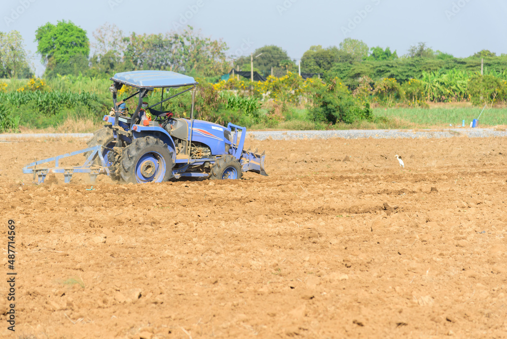 Farmer drive the Tractor Plow the soil for prepair sapling the vegetable Farmer drive the Tractor Plow the soil for prepair sapling the vegetable