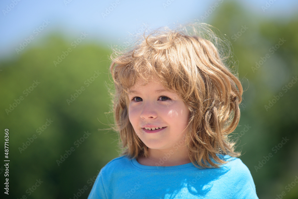 Closeup attractive laughing boy. Child emotions concept. Portrait of young smiling kid outdoor. Blur background. Closeup attractive laughing boy. Child emotions concept. Portrait of young smiling kid outdoor. Blur background.