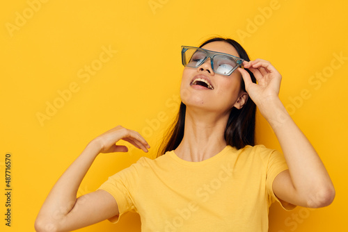 beautiful woman of asian appearance in yellow t-shirt glasses fashion