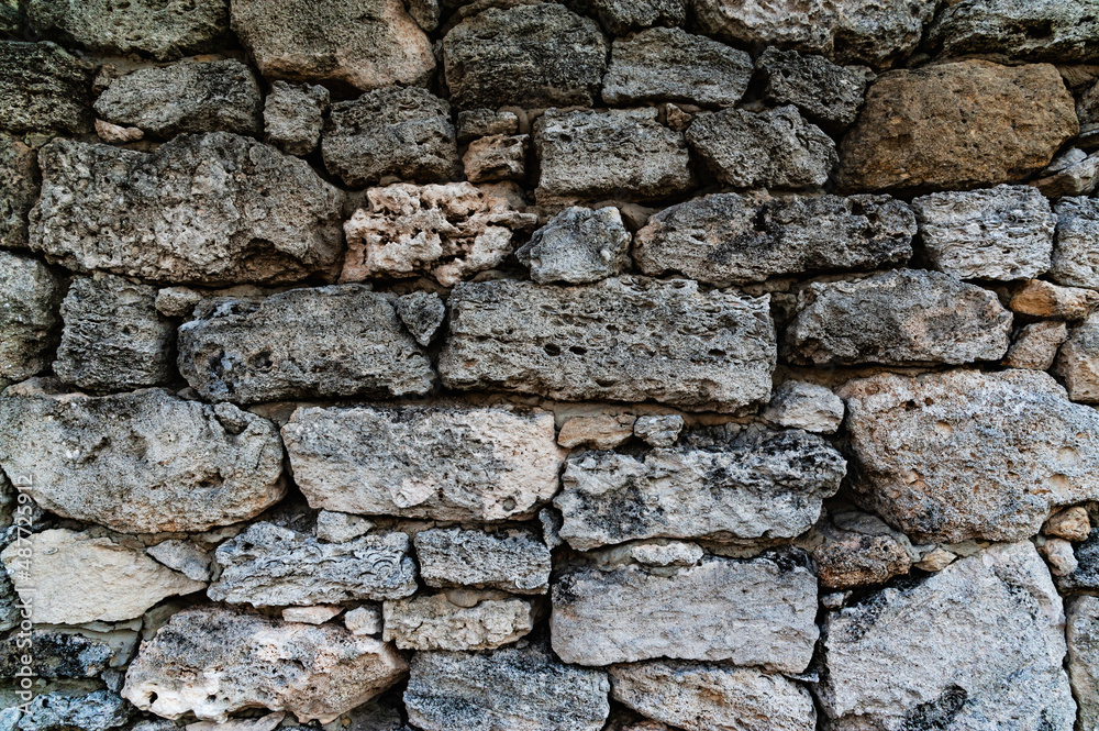 Old wall of stone shell rock of arbitrary shape. Background with wall from shell rock material Old wall of stone shell rock of arbitrary shape. Background with wall from shell rock material