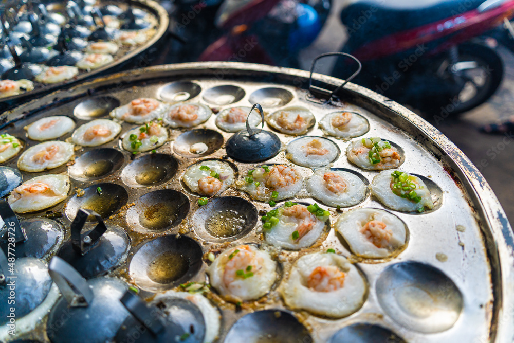 Vietnamese savory mini shrimp pancakes (Banh Khot) with herbs, eggs, shrimps and fish Sauce - Vietnamese cuisine.