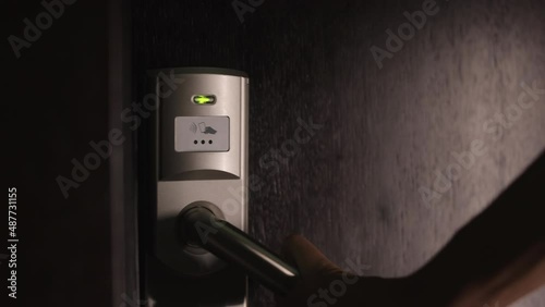 Female person using electronic keycard for opening door at modern hotel. Close up of woman entering her private room with security code. photo