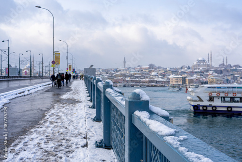 Galata Bridge on a winter day covered with snow in Istanbul, Turkey. © gokhan