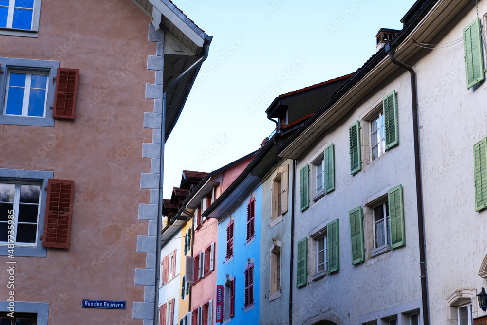 Beautiful historic houses with colorful facades at the little medieval town of St-Ursanne, Canton Jura, on a winter morning. Photo taken February 7th, 2022, Saint-Ursanne, Switzerland.