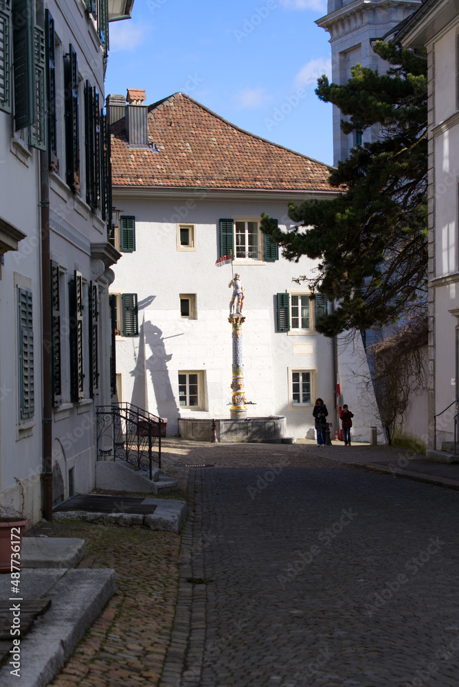 Sculpture of medieval soldier on top of fountain with flag on a sunny winter day. Photo taken February 7th, 2022, Solothurn, Switzerland.	