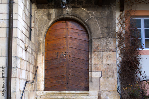 Close-up of wooden door at entrance to church on a sunny winter morning at little medieval town St-Ursanne. Photo taken February 7th, 2022, Saint-Ursanne, Switzerland.