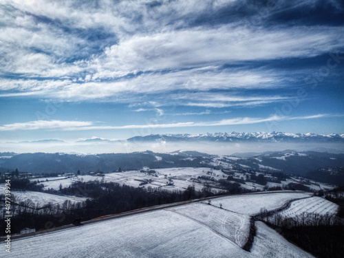 The village of Murazzano with its tower and the village in the Piedmontese Langhe in the province of Cuneo, on a snow-covered winter day