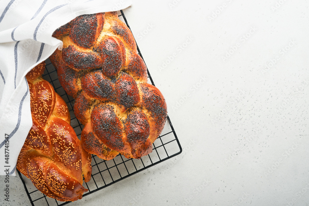 Challah bread. Sabbath kiddush ceremony composition. Freshly traditional baked homemade braided challah bread for Shabbat and Holidays on light grey background, Shabbat Shalom. Top view. Copy space. - obrazy, fototapety, plakaty 