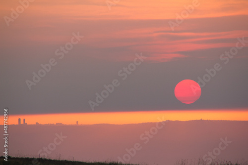 The bright red sun sets over the horizon. Red yellow sunset. High quality photo photo