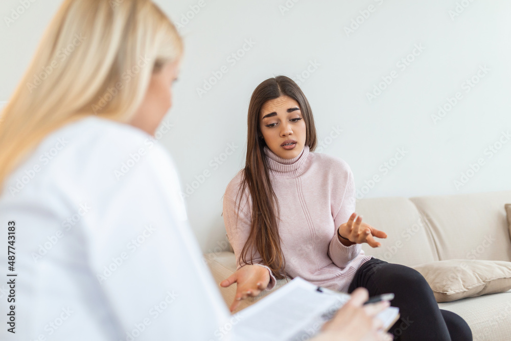 Woman at therapy session. Attentive psychologist. Attentive psychologist holding pencil in her hands making written notes while listening to her client