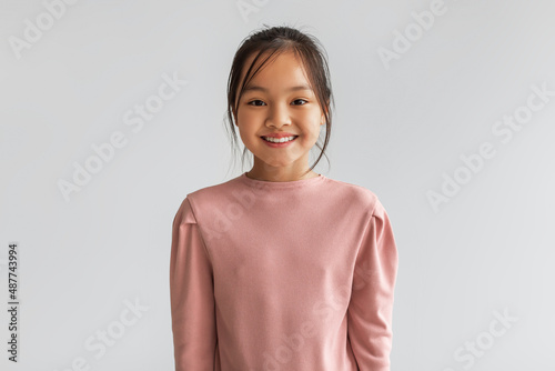 Portrait Of Cheerful Asian Kid Girl Posing On Gray Background