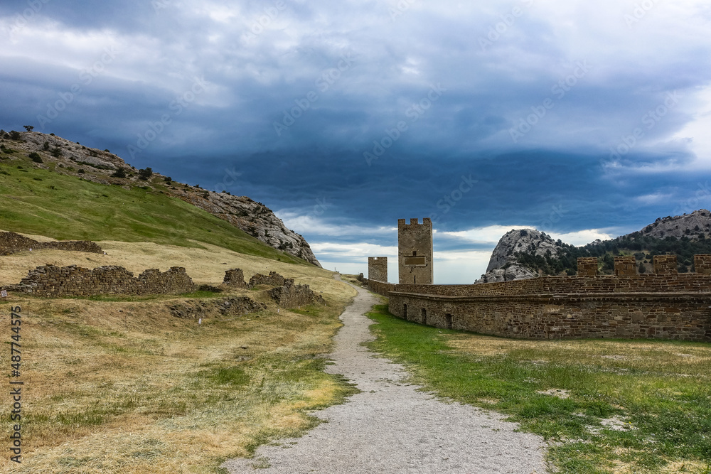 A picturesque view with a stormy sky of the Fortress Mountain and the ancient fortress. Genoese Fortress, Sudak, Crimea