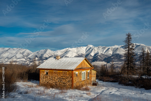 Wooden house on the background of snow-capped mountains