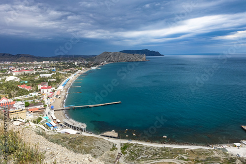 Crimea - May 2021. A line of beaches in the city of Sudak. View from the Genoese fortress on the Sudak Bay. Russia.