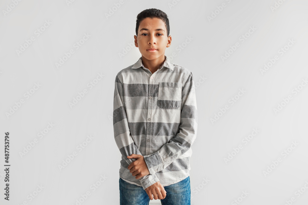 Fototapeta premium Serious Black Preteen Boy Looking At Camera Over Gray Background