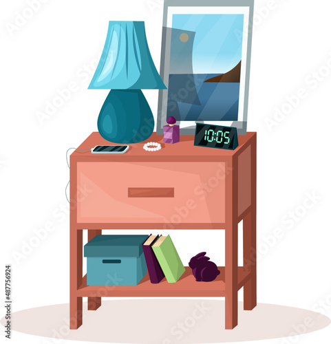 Bedside table in bedroom with phone, clock, lamp