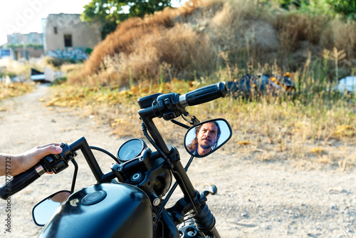 Male reflection on a chopper rear view mirror