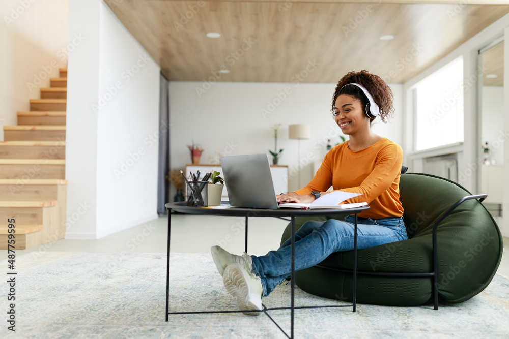 © Prostock-studio - Portrait of smiling black woman using laptop at home
