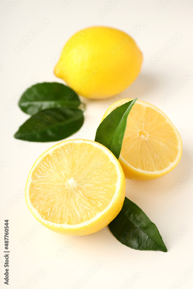 Lemons with leaves on white background, close up
