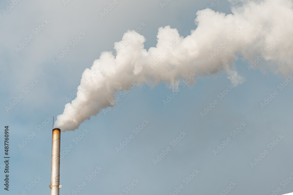 Pipe and smoke.Polluting air with white smoke from industrial chimney outdoors. CO2 emissions.Copy space.