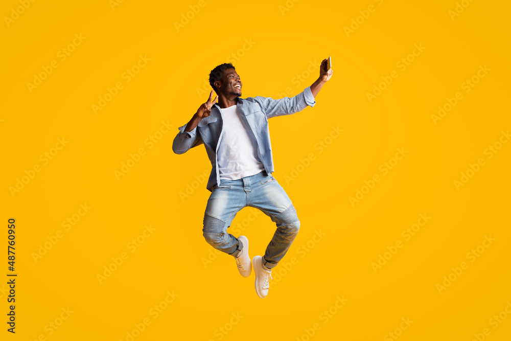 Joyful black guy having fun, taking selfie on smartphone Joyful black guy having fun, taking selfie on smartphone