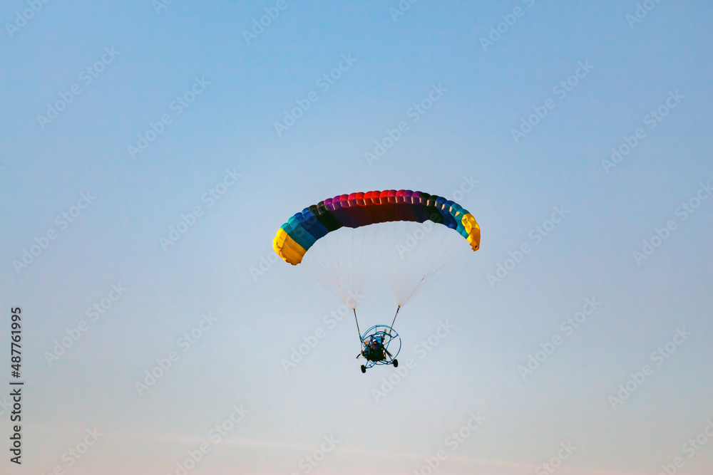 Paragliding on a blue sky. Sport in which the players fly in the air using paragliders Paragliding on a blue sky. Sport in which the players fly in the air using paragliders