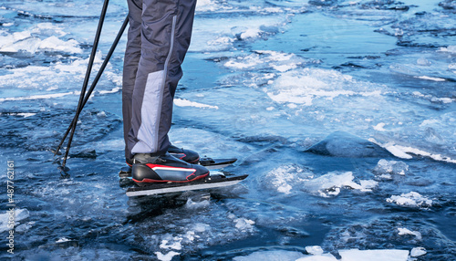 Special long skates for long distances. Fastening for ski boots.Tourists skating on the frozen Lake Baikal.