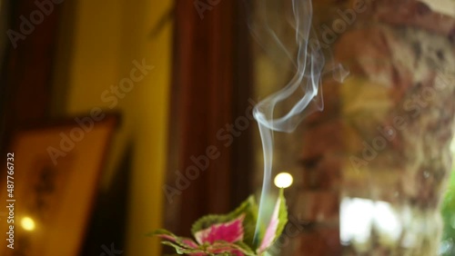 Smoke from incense stick rising upwards photo