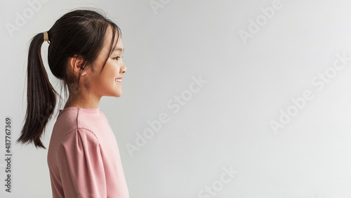 Cheerful Japanese Preteen Girl Posing Looking Aside, Gray Background